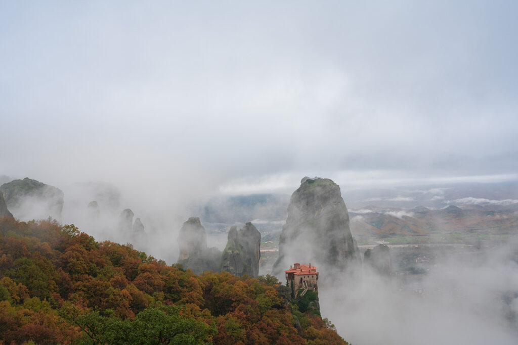 Deze sfeervolle foto toont het iconische landschap van Meteora, gelegen in Thessalië, Griekenland. Mystieke rotsformaties rijzen op uit een zee van mist, terwijl een eeuwenoud klooster zich vastklampt aan de steile pieken. De combinatie van herfstkleuren, wolken en monumentale rotsen creëert rust, diepte en tijdloosheid. Als wanddecoratie brengt dit kunstwerk een gevoel van sereniteit en reisbeleving in woonkamer, kantoor of hotellobby. De foto past perfect bij een modern, minimalistisch of natuurlijk interieur en is ideaal voor liefhebbers van reizen, spiritualiteit, natuur en indrukwekkende Europese landschappen. Hoogwaardige printkwaliteit zorgt voor blijvende kleurkracht en detail op elk gekozen materiaal, voor jarenlang kijkplezier.